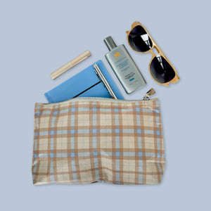 Beige and ice blue plaid cosmetic zipper pouch with sunscreen and sunglasses inside