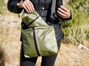 Woman pulling a shimmer green pouch out of shimmer green purse