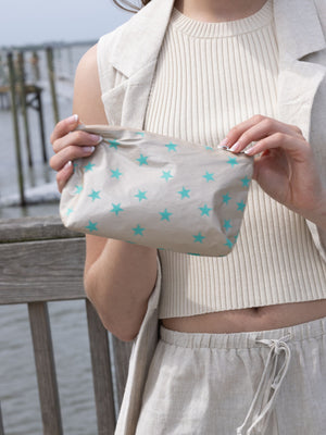 Woman holding mini zipper pouch beige with myriad green stars