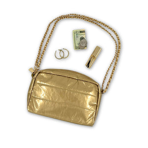 Gold earrings, twenty dollar bill, and lipstick coming out of gold mini puffer clutch with gold chain 