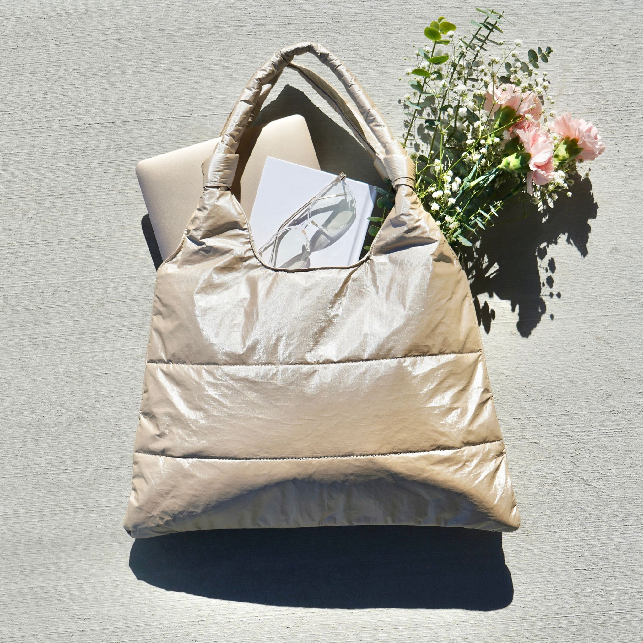 Shimmer beige tote bag with flowers, laptop, journal, and glasses inside