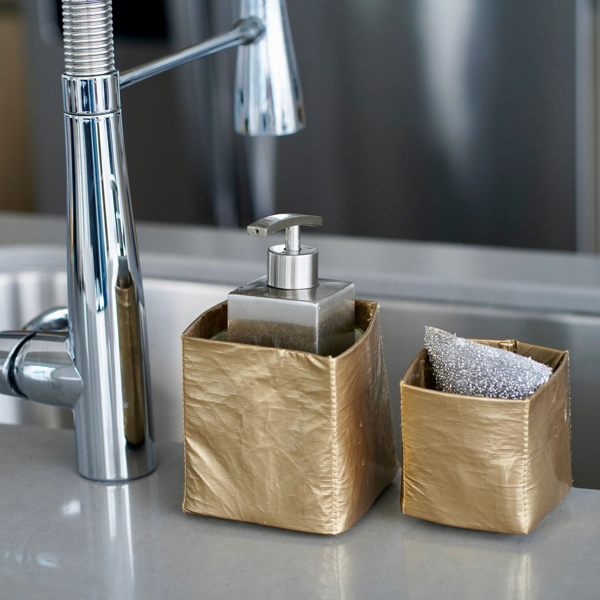 Set of two gold organization cups with soap dispenser and sponge inside